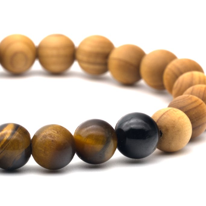 Sandelholz/Tigerauge Armband aus Sandelholz und Tigerauge auf weißem Hintergrund.
