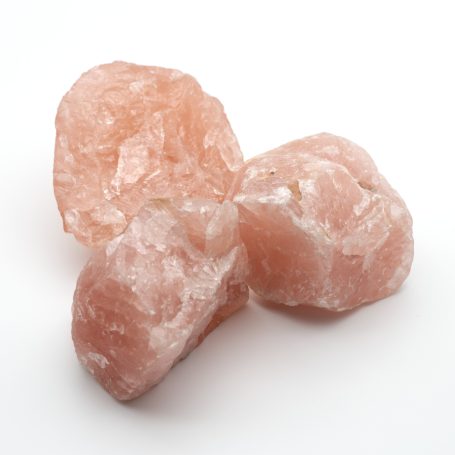 Drei Rosenquarz-Rohsteine in kräftigem Rosa auf weißem Hintergrund