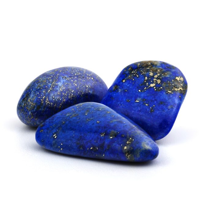 Lapislazuli Drei kräftig blaue Lapislazuli Trommelsteine mit Pyrit auf weißem Hintergrund.