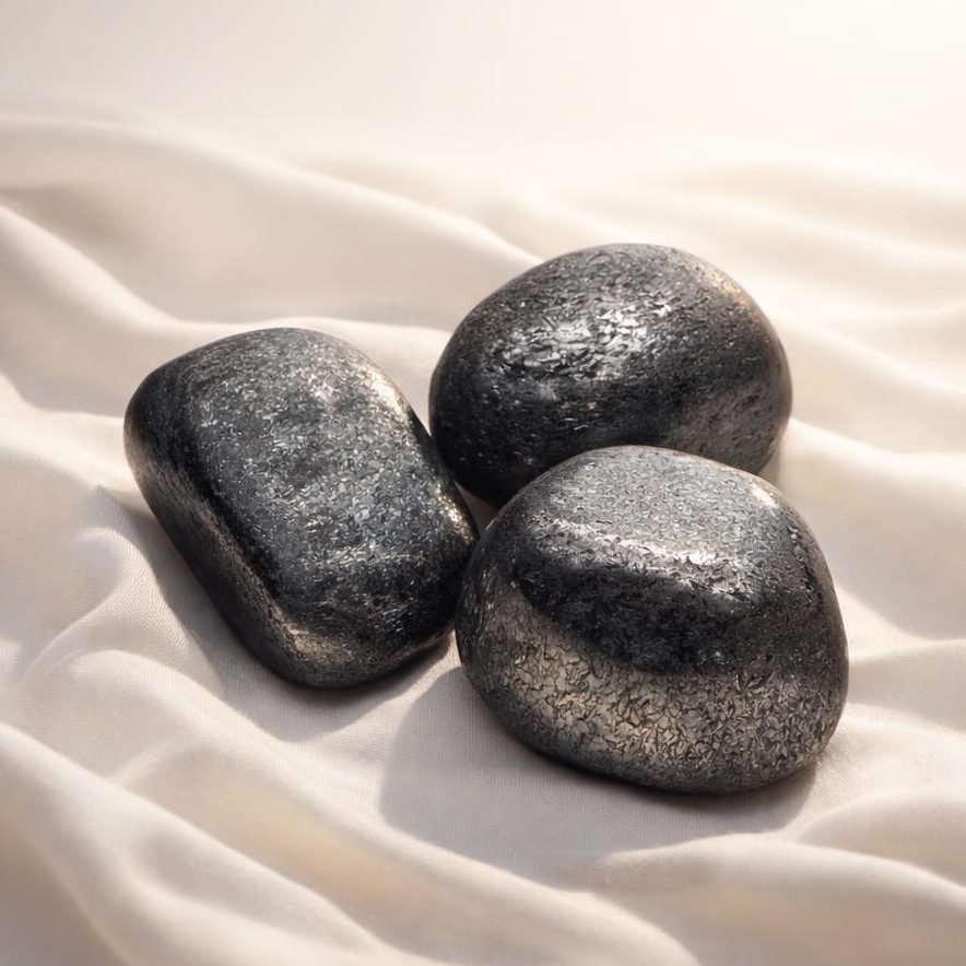 Specular Hämatit Trommelsteine auf hellem Stoffhintergrund als Edelstein-Klassiker.