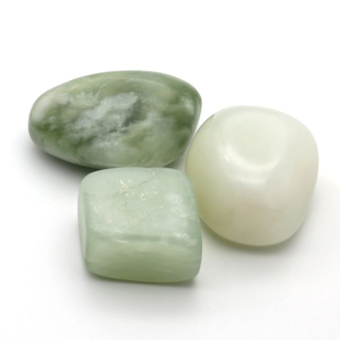 Hellgrüne Serpentin-Jade (China-Jade) Trommelsteine auf weißem Hintergrund.