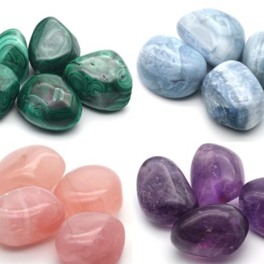 Verschiedene Trommelsteine in Grün, Blau, Rosa und Violett auf weißem Hintergrund.