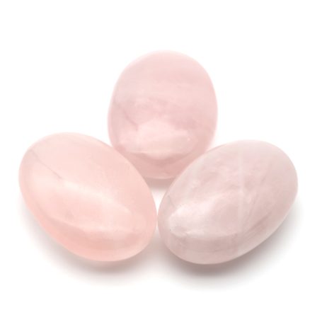 Drei Rosenquarz-Handchmeichler in zartem Rosa auf weißem Hintergrund