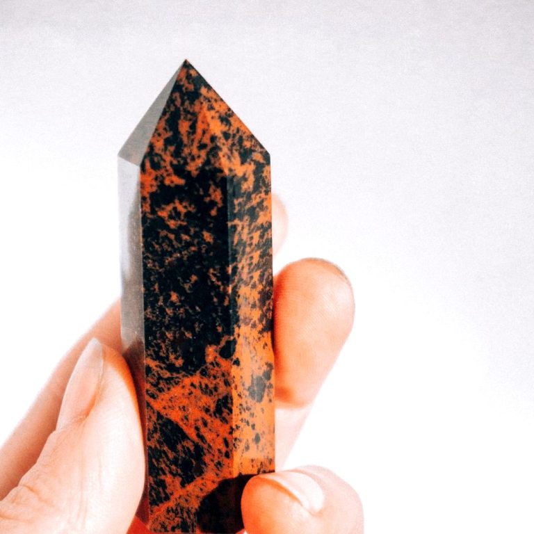 Mahagoni-Obsidian-Spitze in der Hand gehalten – polierter Edelstein mit braun-schwarzer Zeichnung im Edelstein-Lexikon
