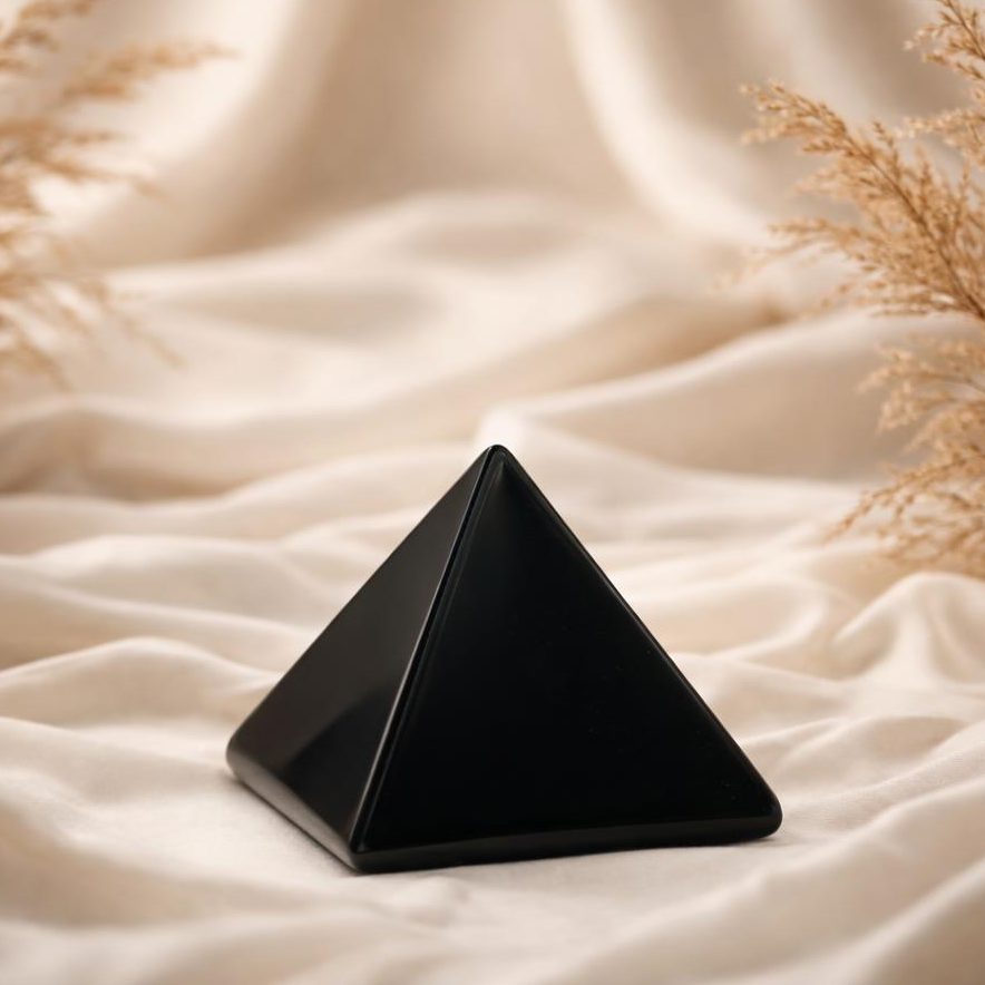 Schwarze Obsidian Pyramide mit Trockengras als Symbol für Schutzsteine