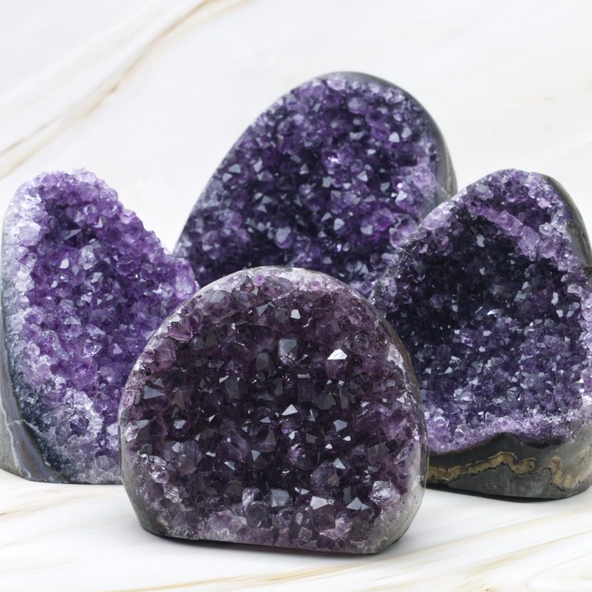 Vierer Gruppe Amethyst Geoden auf hellem Hintergrund.